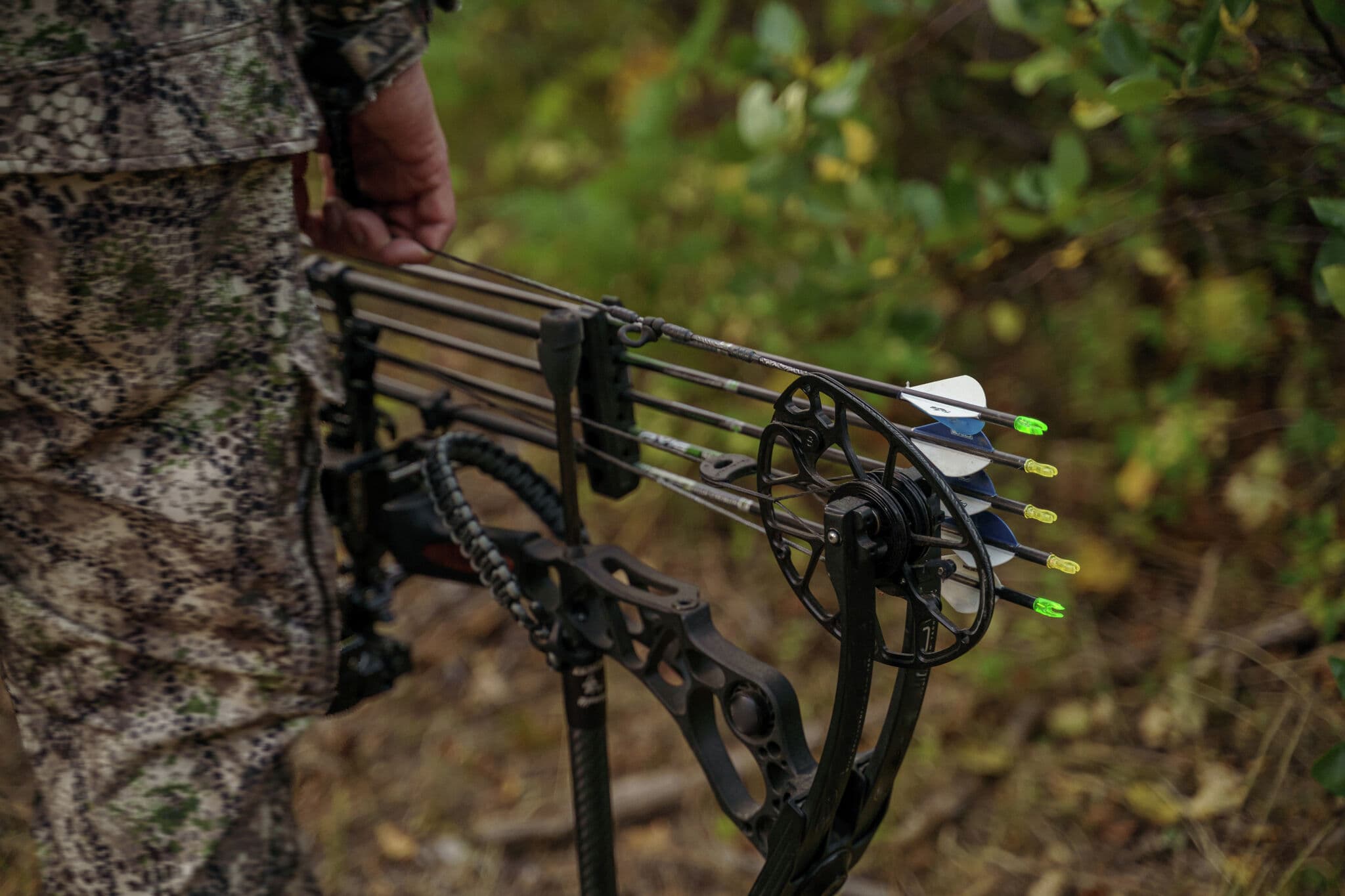 Archer holding compound bow in forest